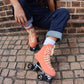 Chuffed Skates peach pink roller skates on brick floor