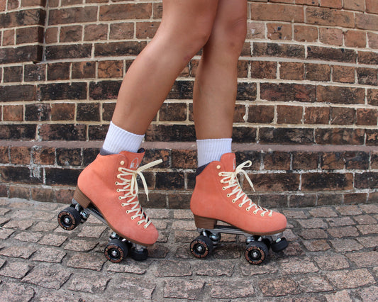 Chuffed Skates peach pink roller skates with brick background