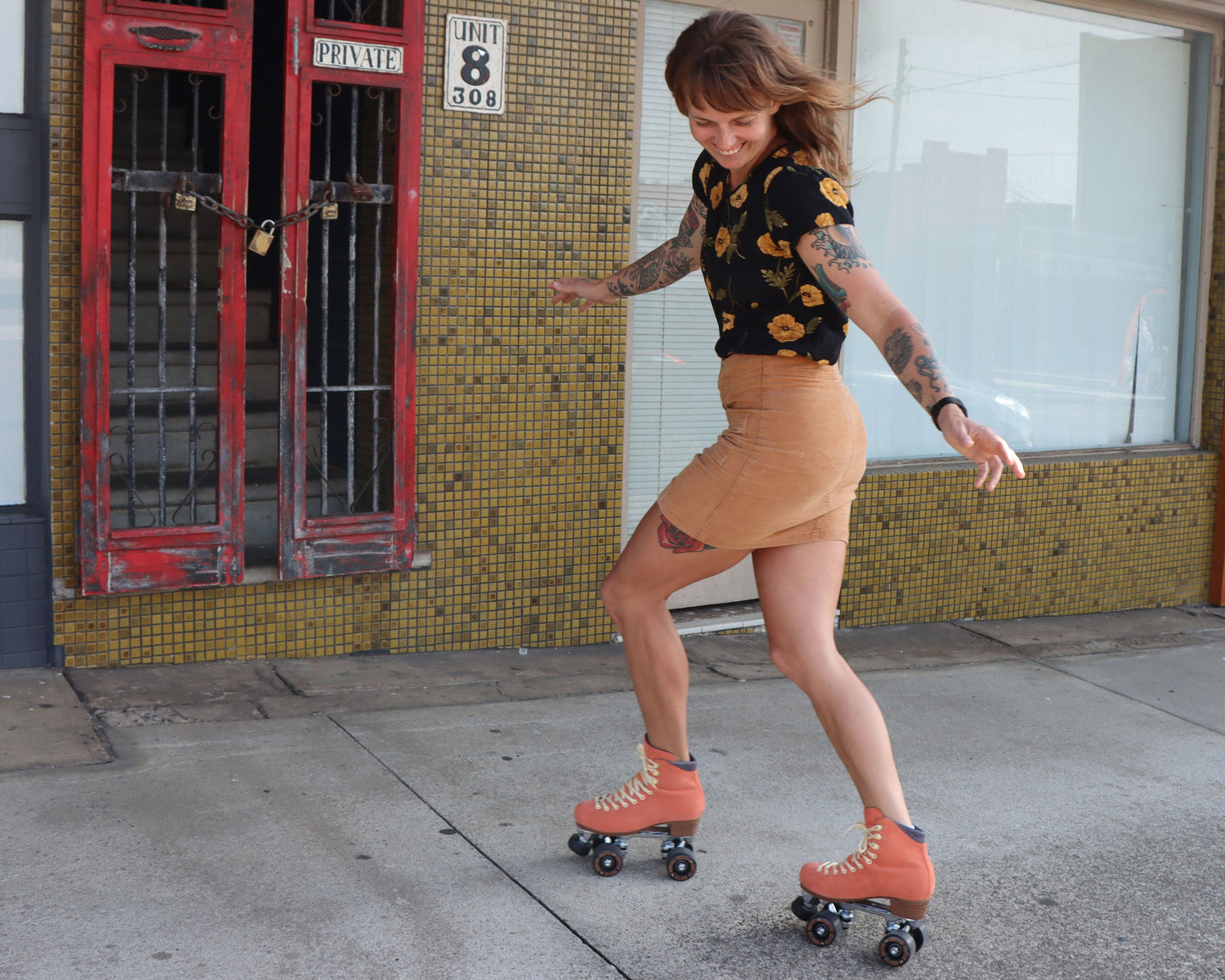 Smiling roller skater wearing Chuffed Skates peach pink roller skates